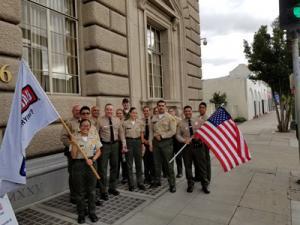 Sheriff Villanueva pictured next to deputies holding up flags