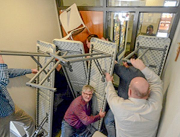 People hiding in a room stacking tables agains door