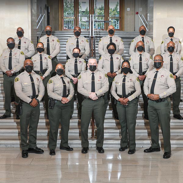 Sheriff standing with staff in the hall of the Hall of Justice building