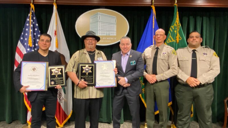 image of award recipeints standing next to the sheriff. Two pastors and the sheriff is next to a podium.