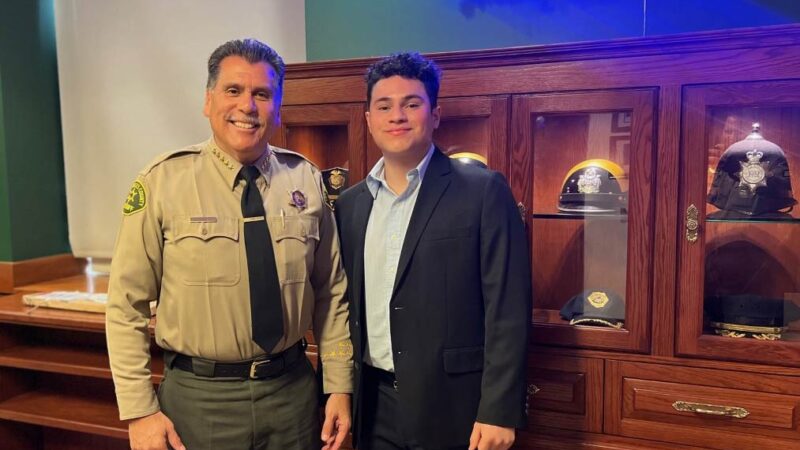 Luis standing next to sheriff luna. Luna is in uniform.