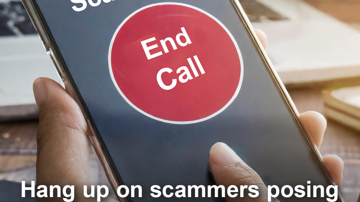 A hand holding a cell phone; on the screen, the caller ID says "Scammer" with a large red "End Call" button below
