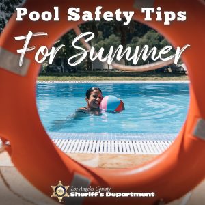Pool Safety Tips for Summer. Image of an orange life saver ring, through the ring you can see a girl floating in the pool playing with a beach ball. She is smiling at the camera.